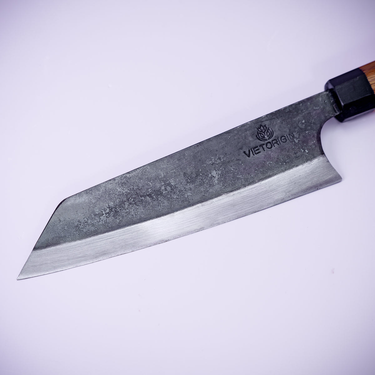 Close-up of the hand-forged bunka blade with kurouchi finish and angled tip
